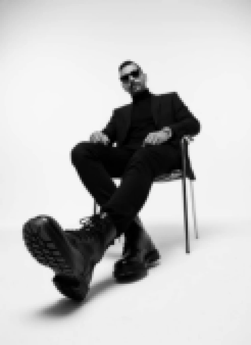 Bold Black-and-White Portrait of a Man Sitting Confidently in a Minimal Studio