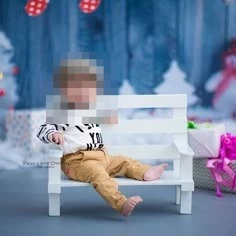 Cute baby sitting on a white bench in a festive winter background