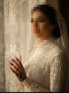 Elegant Bride in Lace Gown Standing by Window in Warm Golden Light