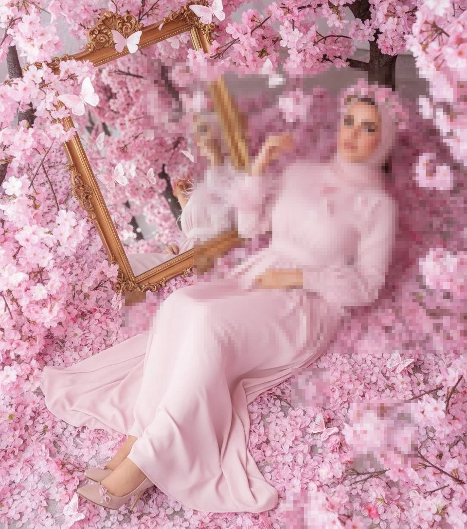 Elegant woman in pink dress lying among cherry blossoms with golden mirror
