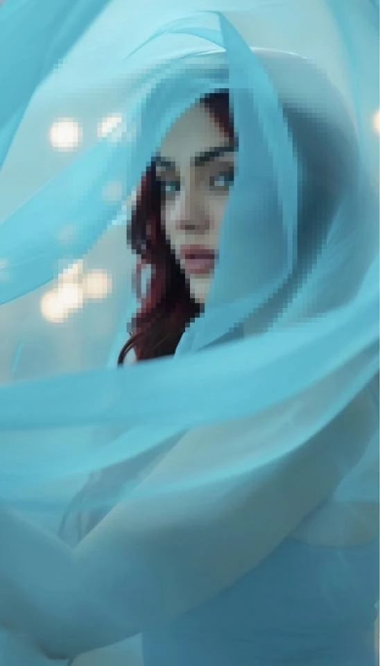 Ethereal portrait of a woman wrapped in flowing blue fabric with soft dreamy lighting