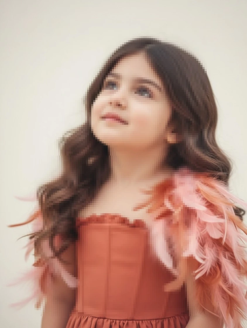 Little girl in terracotta feather dress looking up with soft natural light