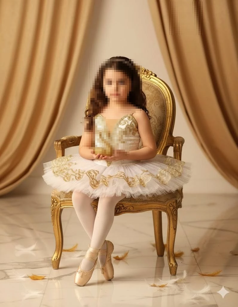 Little girl in white and gold ballet dress sitting gracefully on golden chair