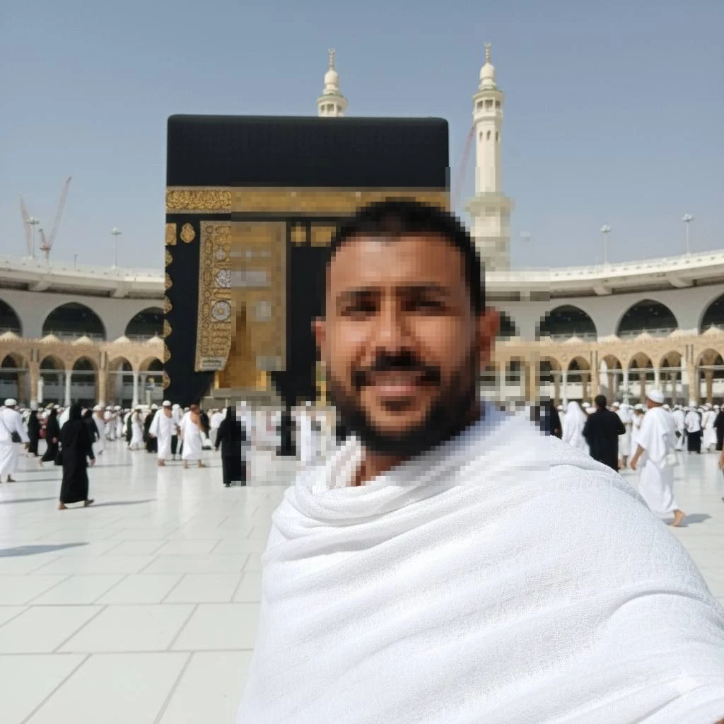 Man in White Ihram Standing Before Kaaba in Mecca During Pilgrimage