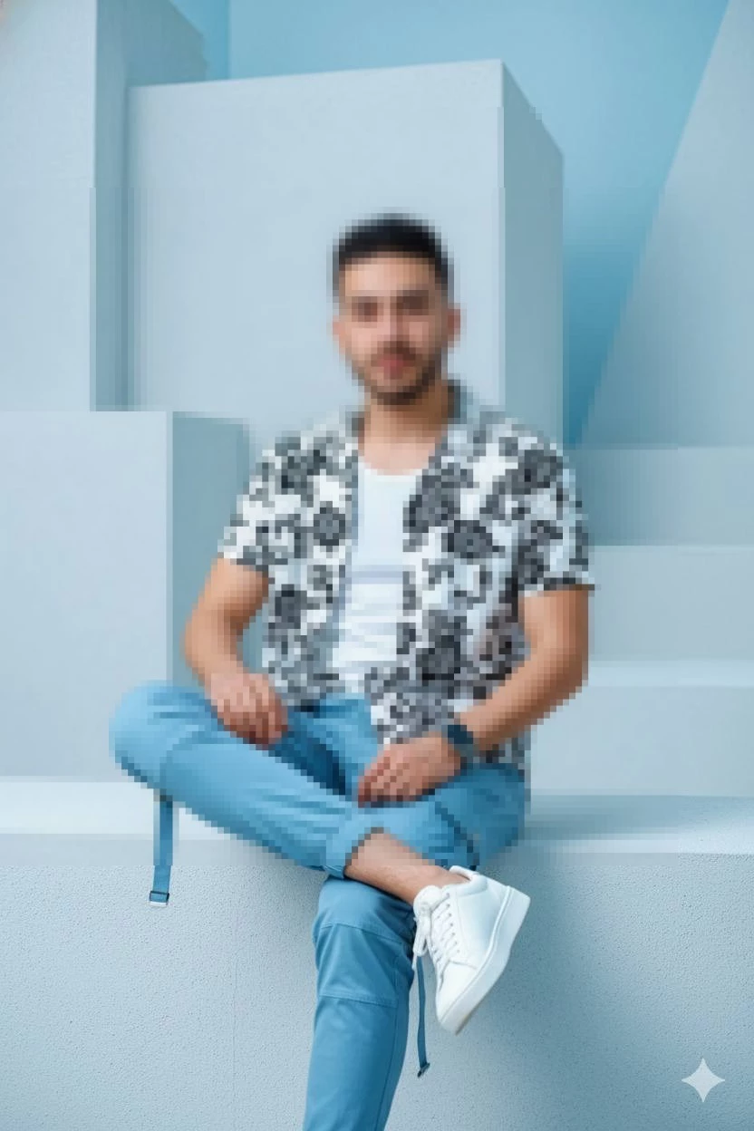 Man sitting on minimalist blue steps wearing floral shirt and blue pants