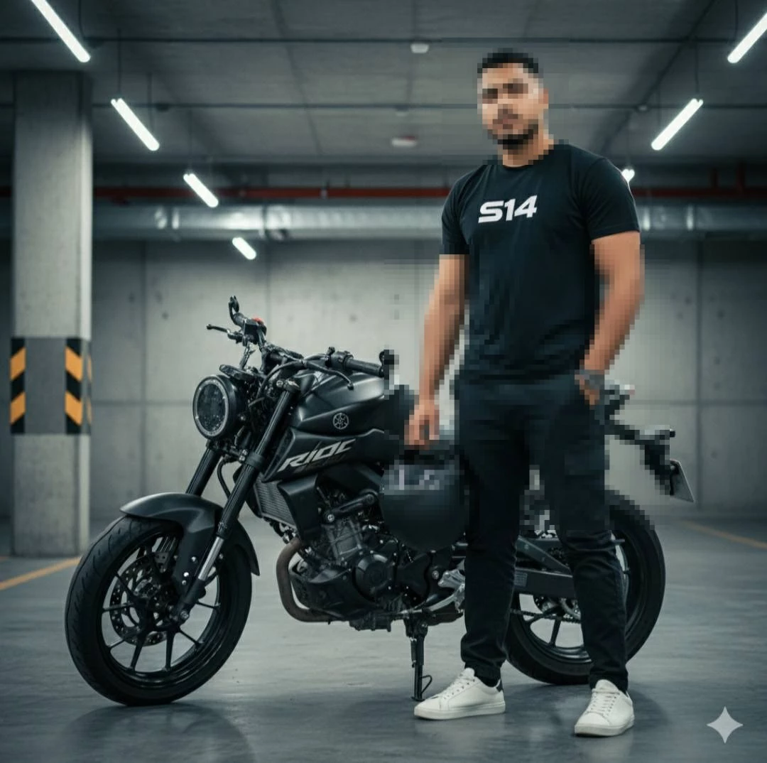 Man Standing with Black Motorcycle in Underground Garage Wearing Bla