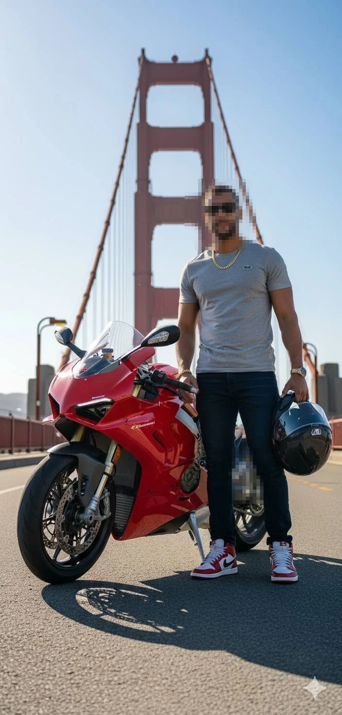 Man with red Ducati motorcycle posing confidently on bridge at sunset