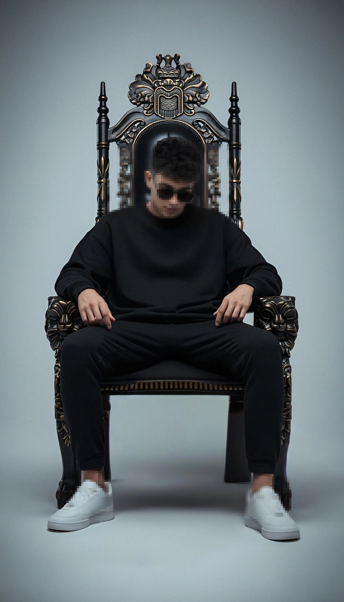 Stylish Man in Black Outfit Sitting Confidently on Ornate Royal Throne