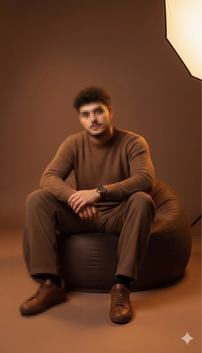 Stylish man sitting confidently on a bean bag in a warm brown studio setting