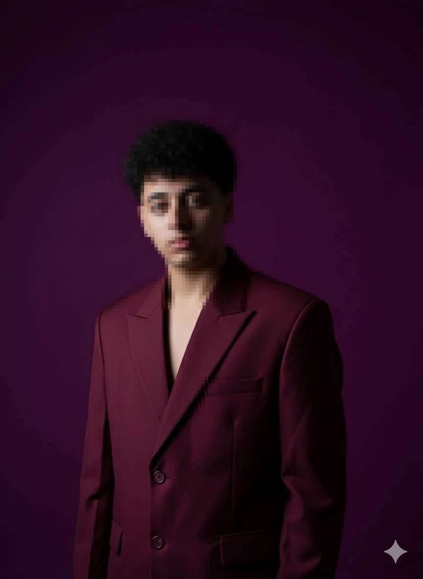 Young Man in Maroon Suit Posing Confidently Against Purple Background