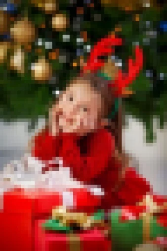 Child in Red Sweater Smiling with Christmas Gifts and Reindeer Antlers
