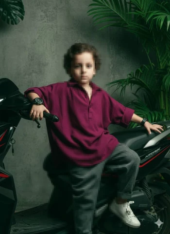 Confident Child Posing on a Modern Black Scooter in a Stylish Studio Setting