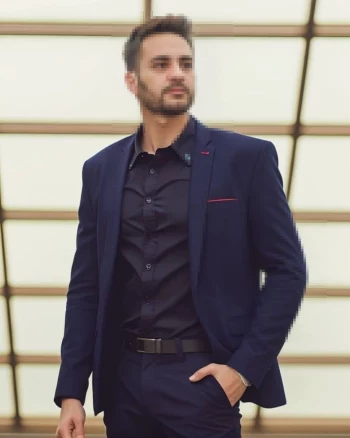 Confident Man in Navy Blue Suit Posing in Modern Architectural Setting