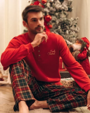 Cozy Christmas Portrait of a Man in Red Holiday Pajamas by the Festive Tree