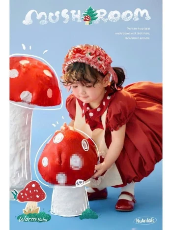 Cute girl in red dress with giant mushrooms – kids fashion photoshoot