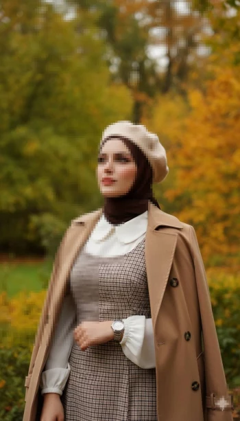 Elegant autumn portrait of a woman in a beige coat and beret in the park