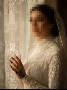 Elegant Bride in Lace Gown Standing by Window in Warm Golden Light