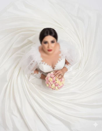 Elegant bride in white lace gown holding pink roses from top view