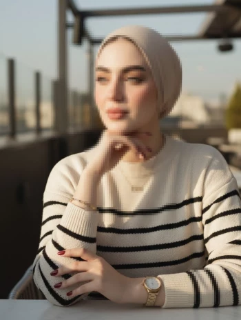 Elegant woman in beige hijab and striped sweater under warm sunset light