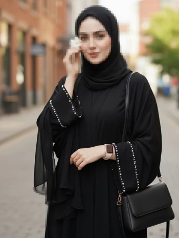 Elegant woman in black abaya holding white flower on a sunny city street
