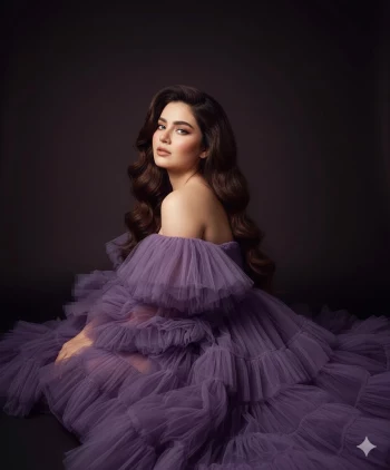 Elegant woman in lavender tulle gown posing gracefully in a dark studio setting