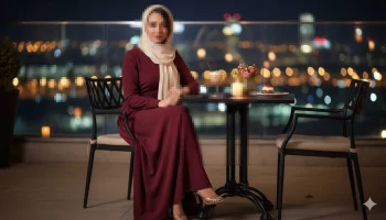 Elegant woman in maroon dress enjoying rooftop dinner with city lights view