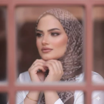 Elegant Woman in Patterned Hijab Looking Out the Window