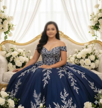 Elegant Woman in Royal Blue Embroidered Gown Sitting Among White Roses