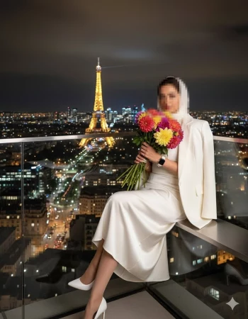 Elegant woman in white holding flowers with Eiffel Tower view at night