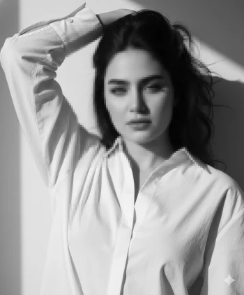 Elegant woman in white shirt posing in natural light black and white portrait