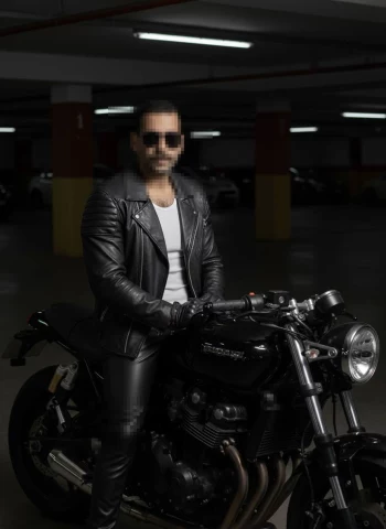 Man in Black Leather Biker Outfit Sitting on a Motorcycle in a Parking Garage