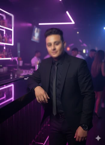 Man in black suit posing confidently at modern neon lit nightclub bar