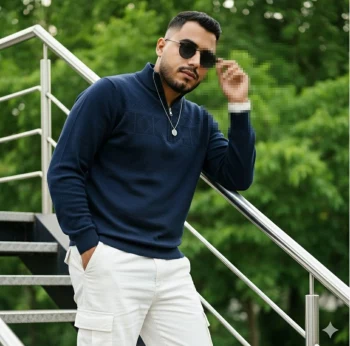 Man in navy sweater and white pants posing confidently on outdoor stairs