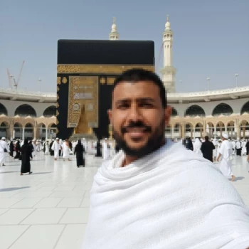 Man in White Ihram Standing Before Kaaba in Mecca During Pilgrimage