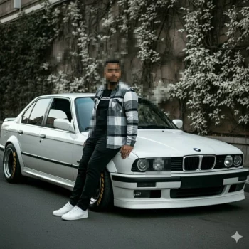 Man leaning on white BMW classic car wearing black and white checkered shirt