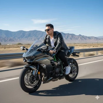 Man riding black sport motorcycle on open highway with mountain backdrop