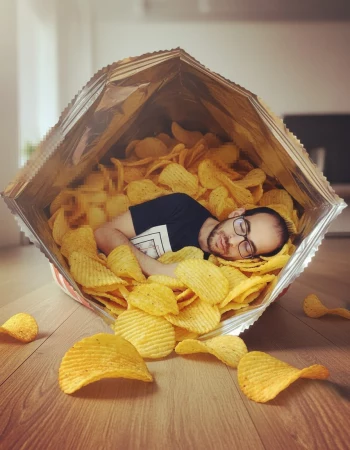 Man Sleeping Inside a Giant Bag of Crispy Potato Chips in a Fun Creative Scene