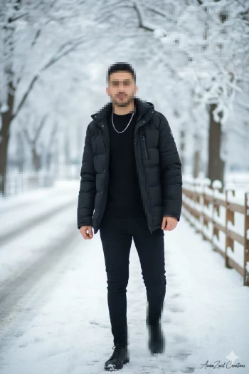 Man walking confidently through a snowy winter path in stylish black outfit
