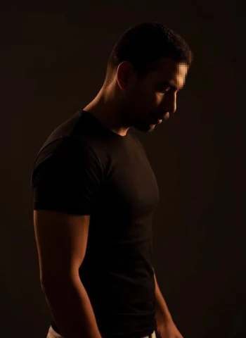 Moody portrait of a man in black t-shirt under soft dramatic lighting