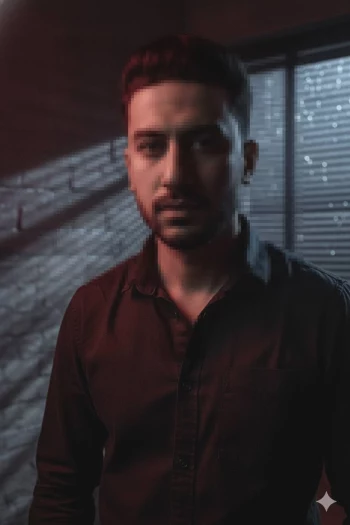 Moody portrait of man in dark shirt with cinematic red and blue lighting