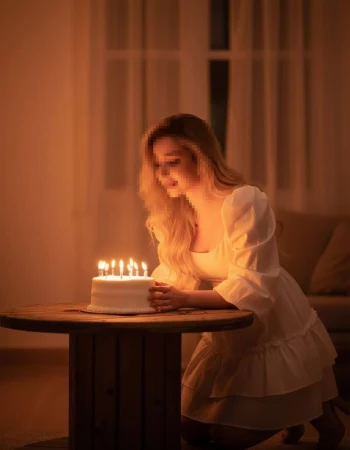 Smiling girl in colorful dress stanWoman in white dress smiling at birthday cake with glowing candlesding with cartoon cat in magical garden