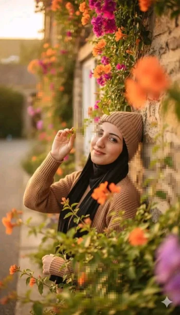 Smiling woman in brown outfit standing by stone wall covered with colorful flowers