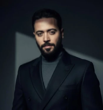 Stylish man in black suit and turtleneck under dramatic studio lighting