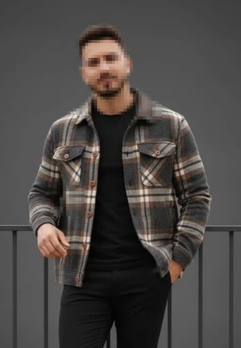 Stylish man in checkered jacket and black outfit posing confidently outdoors