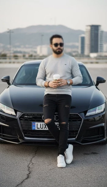 Stylish man leaning on black luxury car wearing grey sweater and sunglasses