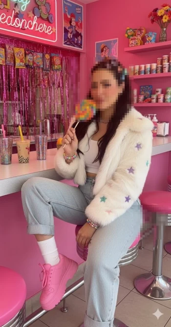 Stylish Woman in Retro Candy Café Holding Rainbow Lollipop