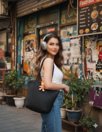 Stylish woman with headphones walking in urban street wearing white top and jeans
