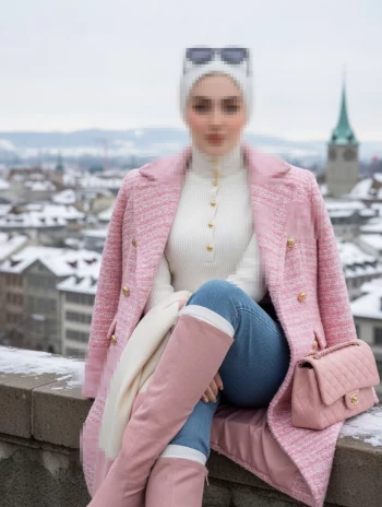 Winter fashion look in pink coat with snowy European city background
