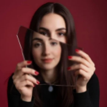 Woman holding mirror shard creating surreal double reflection illusion