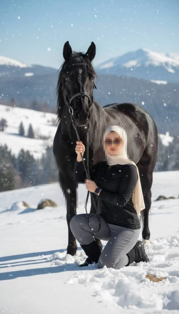 Woman in beige hijab with black horse in snowy mountain landscape